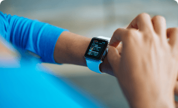 Someone wearing blue long sleeve setting a smart watch